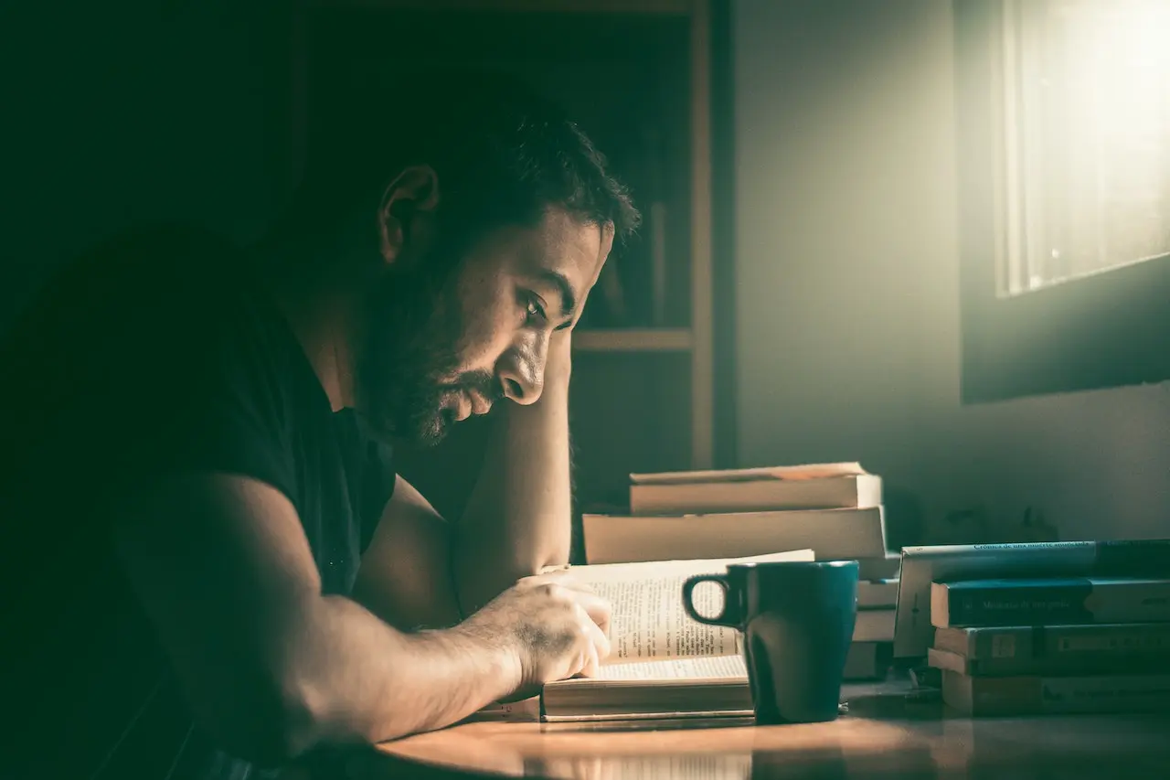 Person practicing mindful reading with notebook and natural lighting